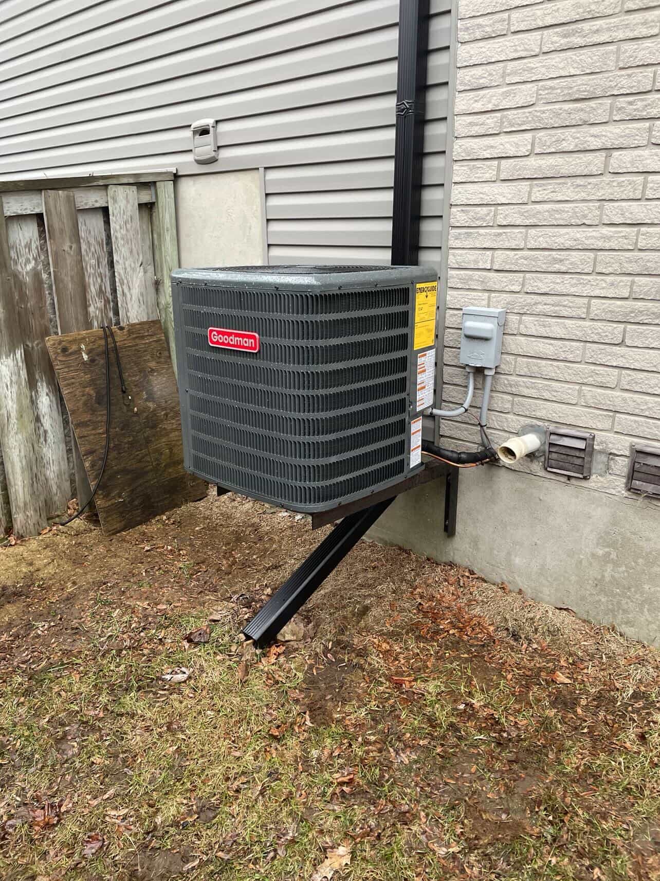 Wall-mounted Goodman AC condenser installed on side of Kitchener home